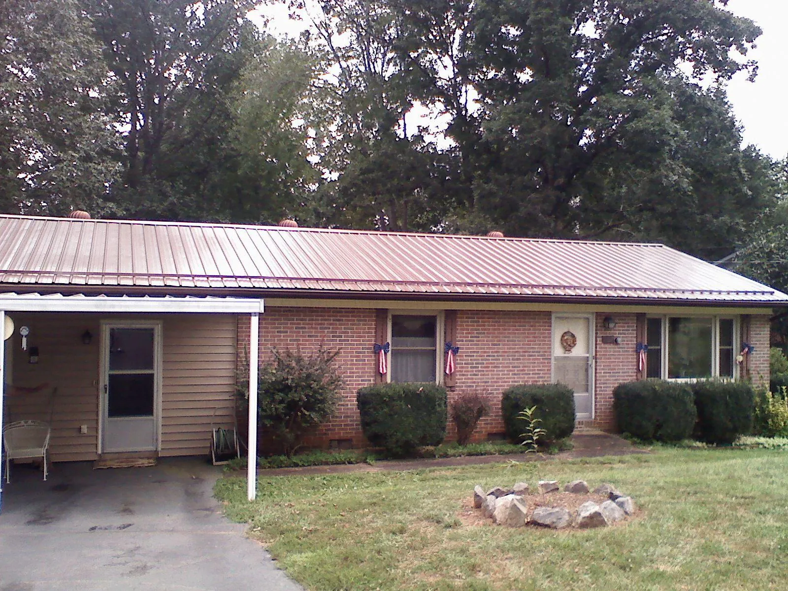 Bronze metal roof and carport on a brick ranch home — Roof Repair work by our crew in Converse